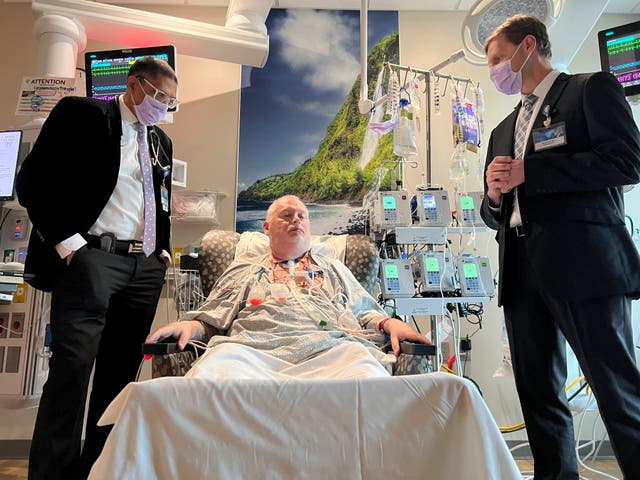 <p>Dr. Girish Mour, left, medical director of Mayo Clinic's Larynx and Trachea Transplant Program, and Dr. David Lott, right, standing on either side of Marty Kedian one week after his transplant surgery in Phoenix, March 8, 2024</p>